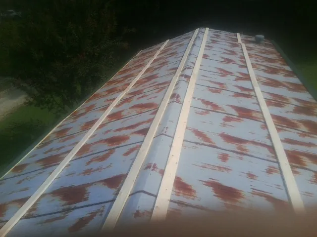 Rusted metal roof panels with new wood purlins before replacement — Storm Damage Roof Repair in Amboy by Roofing Brothers